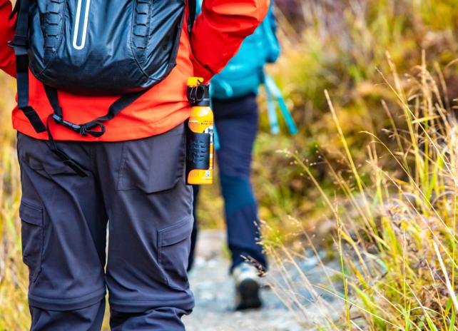 Bear spray self-defense attached to backpackers when hiking Bear spray self-defense attached to backpackers when hiking