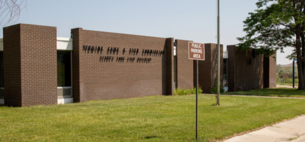 The front brick exterior of the Clark's Fork Fish Hatchery with a green lawn in the foreground.